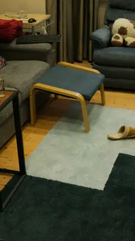 Phone walkthrough frame: lounge room with footstool and rug